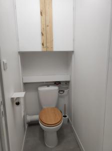 a small bathroom with a toilet with a wooden seat at Chamrousse 1750 - Le Taillefer - Appartement classé 3 étoiles in Chamrousse