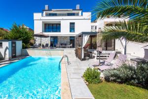 a villa with a swimming pool and a house at Sun & Sea Villa in Krk