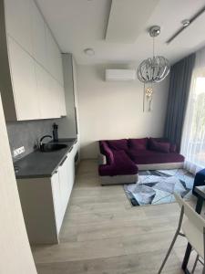 a kitchen and a living room with a couch at Mikis apartament, Mano Jūra 2, Kunigiškiai in Palanga