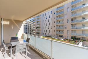 un apartamento con balcón con mesa y sillas y un edificio en Panier, Major, appartement de 47 m2, parking et terrasse, en Marsella