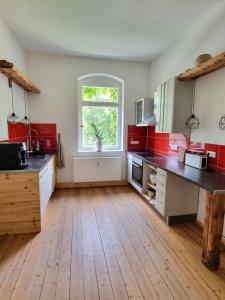 a kitchen with red and white cabinets and a window at Zeitreise: Wohnen im Herrenhaus genau zw. L u. DD in Mügeln
