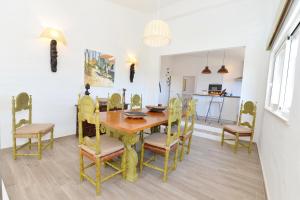 uma sala de jantar com uma mesa de madeira e cadeiras em Tower Villa w Infinity Pool em Olhão
