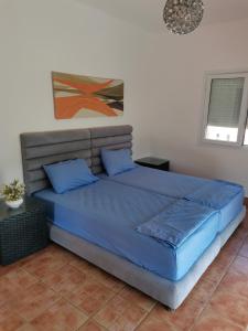 Una cama con almohadas azules en un dormitorio en Luxuary Beach Villa Saidia Morocco, en Saidia 