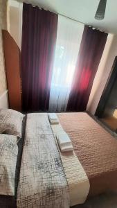 a bedroom with two twin beds and curtains at Guest House - Гостевой частный дом in Dnipro