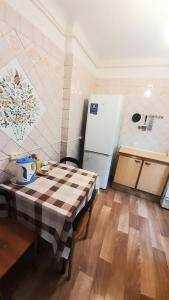 a small kitchen with a table and a refrigerator at Guest House - Гостевой частный дом in Dnipro