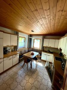 eine Küche mit einem Tisch und einer Holzdecke in der Unterkunft Alpine cottage with exceptional view in Mayrhofen