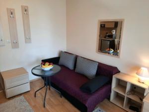 a living room with a purple couch and a table at Apartments in Aspen Suites in Bansko