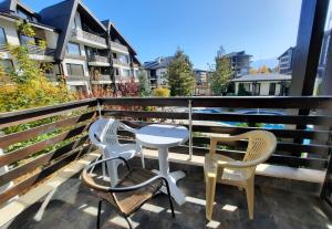 a table and chairs sitting on a balcony at Apartments in Aspen Suites in Bansko