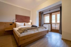 um quarto com uma cama de madeira e uma grande janela em Apart Leitner em Lermoos