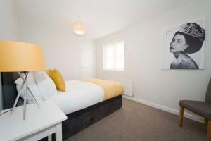 ein Schlafzimmer mit einem Bett und einem schwarz-weißen Bild in der Unterkunft Marlborough Cottage in Stockton-on-Tees