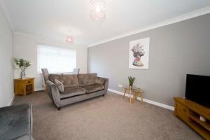 a living room with a couch and a television at Marlborough Cottage in Stockton-on-Tees
