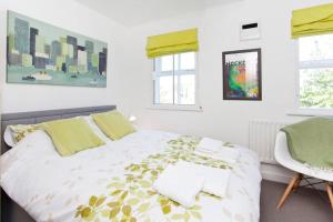 a white bedroom with a bed and a chair at Walking distance to racecourse and city centre in York