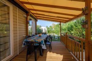 a wooden deck with a table and chairs on it at Mobil home Queen Margaret in Fréjus