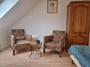 1 dormitorio con 2 sillas, 1 mesa y 1 cama en Le Vivien, en Romorantin-Lanthenay