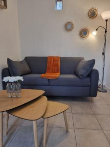 sala de estar con sofá azul y mesa en Le Vivien, en Romorantin-Lanthenay