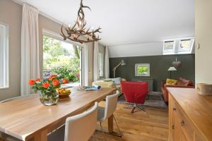 comedor y sala de estar con mesa y sillas en Boshuisje, en Olst