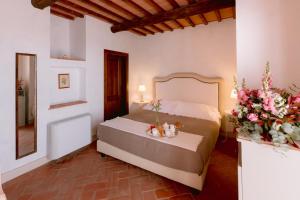 皮恩扎的住宿－博爾戈聖特安布羅吉奧度假村，一间卧室,床上放着鲜花