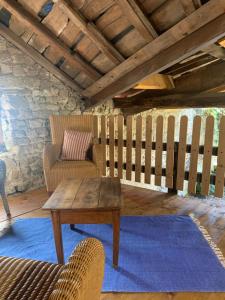 a living room with a wooden table and a chair at Le Gîte de Buffetières in Saint-Romain-de-Popey