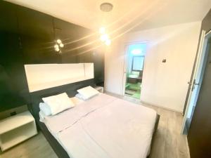 1 dormitorio con 1 cama blanca grande y pared negra en CASA DIEGO, en Bucarest