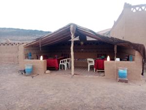 a tent with a table and chairs under it at Auberge Camping Tafraoute Montagnes in Tafraoute Sidi Ali