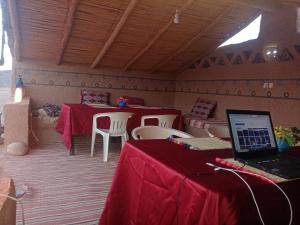 Habitación con 2 mesas y ordenador portátil. en Auberge Camping Tafraoute Montagnes, en Tafraoute Sidi Ali