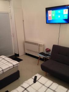 ein Wohnzimmer mit Sofa und Fernseher an der Wand in der Unterkunft Draft ROOM in Valpovo + 8 Fotos
