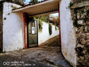 un accès à un bâtiment blanc avec une porte dans l'établissement Tettoeletto, à Castellammare di Stabia