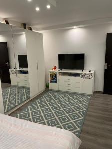 um quarto com uma cama, uma televisão e armários em Apartament Mattias em Călimăneşti