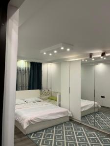 um quarto branco com 2 camas e um espelho em Apartament Mattias em Călimăneşti