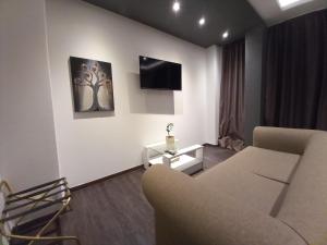 a living room with a couch and a tv on a wall at Filippos - 2BR Lux Apartment - Tsimiski Ladadika - Explore Center by foot - Close to Aristotelous square in Thessaloniki