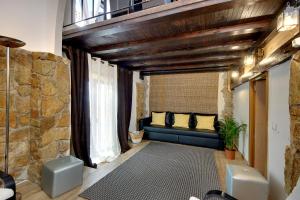 ein Wohnzimmer mit einer blauen Couch und einer Steinwand in der Unterkunft CASA 4 - Perfect location - Sea view by DreamvillasAlbufeira in Albufeira