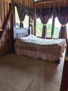 1 dormitorio con 1 cama en una habitación con ventanas en Hospedaje Coffee Mountain en San Isidro