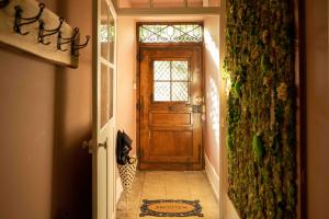 - un couloir avec une porte en bois dans une maison dans l'établissement Le Parc du Magnolia, à Montbéliard