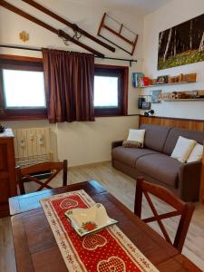 ein Wohnzimmer mit einem Sofa und einem Tisch in der Unterkunft Le Petit Refuge Cervinia in Breuil-Cervinia