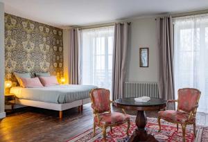 a bedroom with a bed and a table and chairs at Château de Charnizay in Charnizay