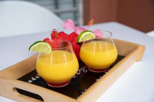 サン・フランソワにあるHôtel Guadeloupe Palm Suitesのトレイに載せたオレンジジュース2杯