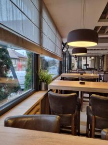 restauracja z drewnianymi stołami i krzesłami oraz dużym oknem w obiekcie Motel Bor w mieście Vitez