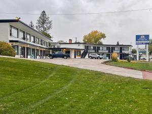 ein Gebäude mit Autos auf einem Parkplatz in der Unterkunft Americas Best Value Inn Polson in Polson