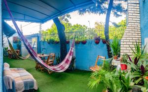 een patio met een hangmat en een tafel en stoelen bij Hostel Dragão do Mar Fortaleza in Fortaleza