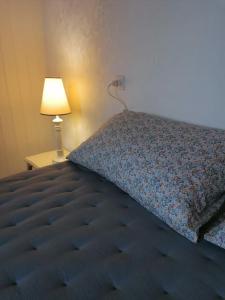 - un lit avec une couette bleue et une lampe dans l'établissement Maison de vacances vue mer, à Pornic