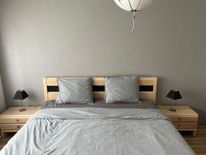 1 dormitorio con 1 cama con 2 mesitas de noche y 2 lámparas en Appartement29 en Wetteren