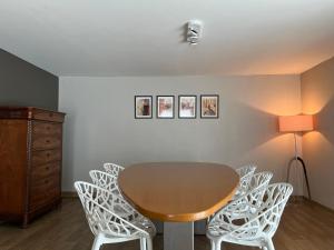 a dining room with a table and white chairs at Appartement29 in Wetteren