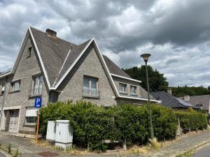 a house with a gray roof on a street at Appartement29 in Wetteren