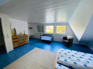Cette chambre mansardée comprend un lit et une commode. dans l'établissement Ferienhaus an der Küste im Luftkurort Hage, à Hage