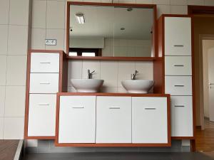 łazienka z 2 umywalkami i lustrem w obiekcie Appartement29 w mieście Wetteren