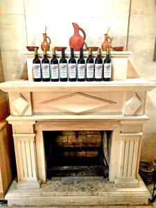 a bunch of bottles of wine sitting on a fireplace at Hotel MASPINDZELO in Kutaisi