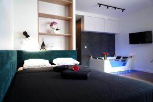 a bedroom with a black bed with a green couch at Relax Jacuzzi Apartment in Krakow