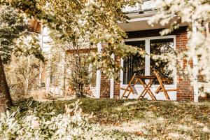 eine Veranda eines Hauses mit einer Holzbank in der Unterkunft Akzent Hotel Zur Grünen Eiche in Bispingen