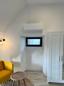 Le Loft Jacuzzi في بلورميل: غرفة معيشة مع أريكة صفراء وطاولة