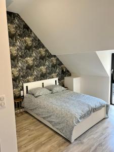 una camera da letto con un grande letto e carta da parati floreale di Le Loft Jacuzzi a Ploërmel